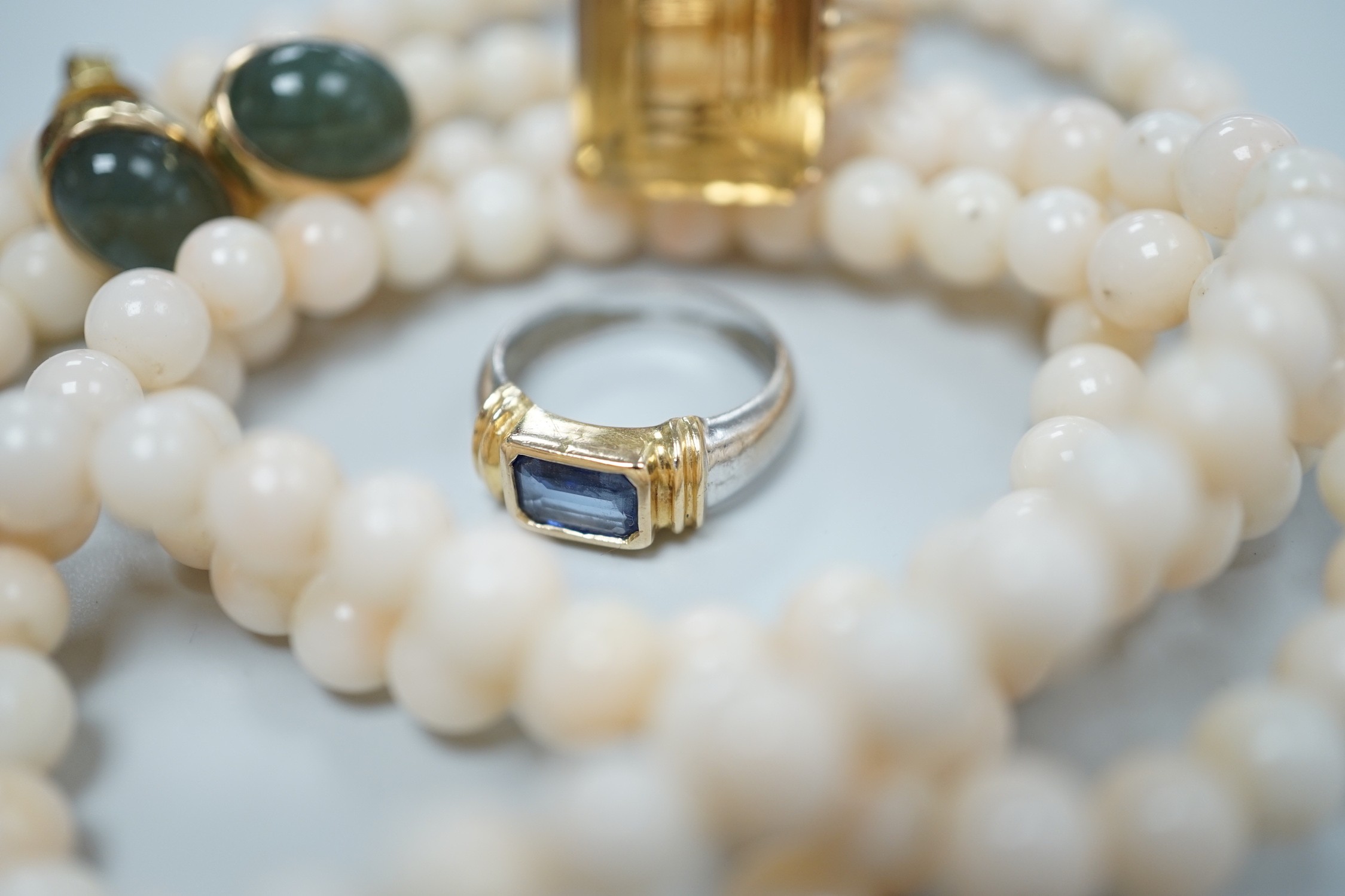 A modern 18k and single stone sapphire set child's ring, size G, a yellow metal and citrine set ring, size J, a pair of 585 and green cabochon set ear studs and a simulated coral bead necklace.